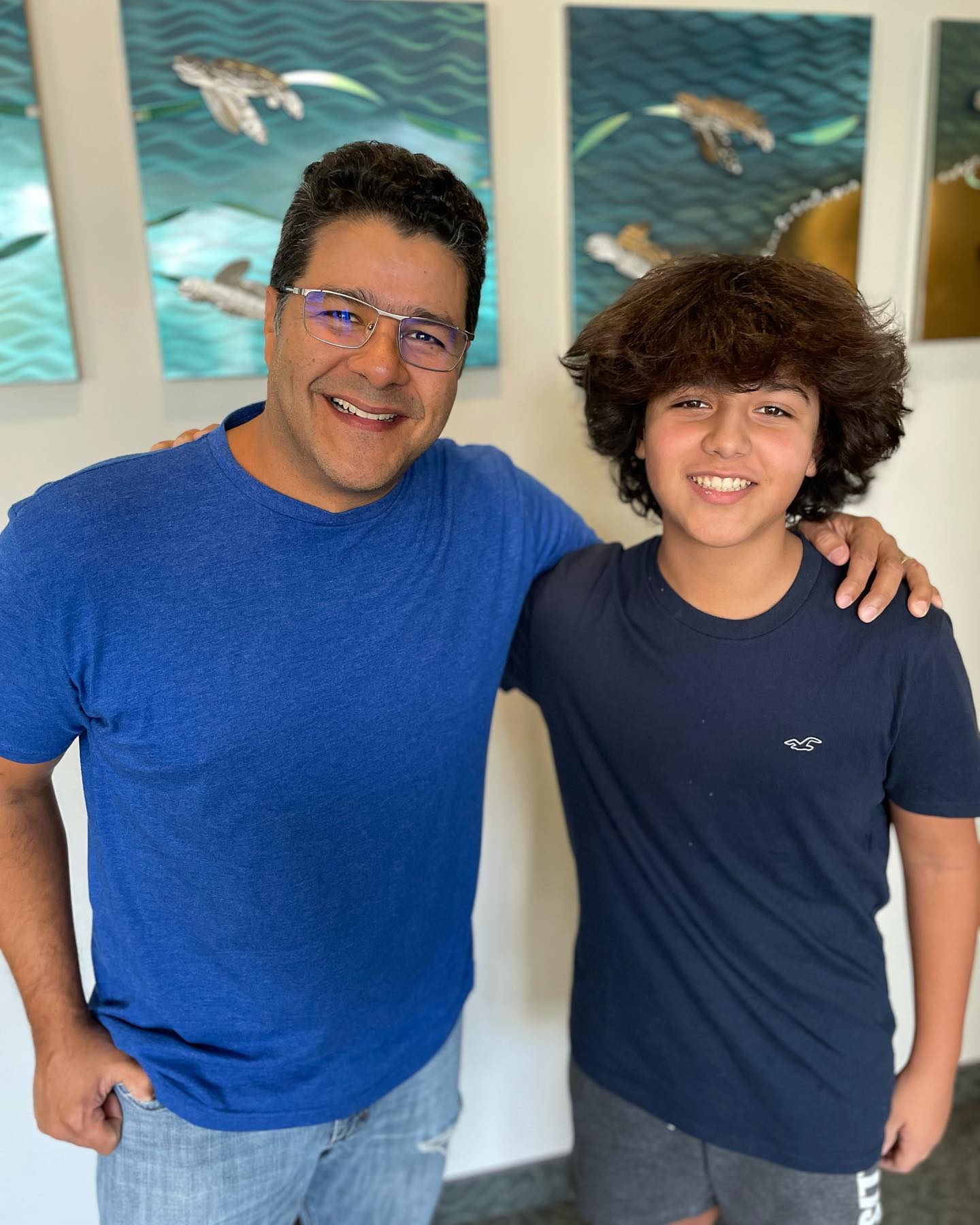 Rolando showing off his Invisalign in Palm Beach Gardens results with son Alejandro who finished braces the same day at Murray Orthodontics