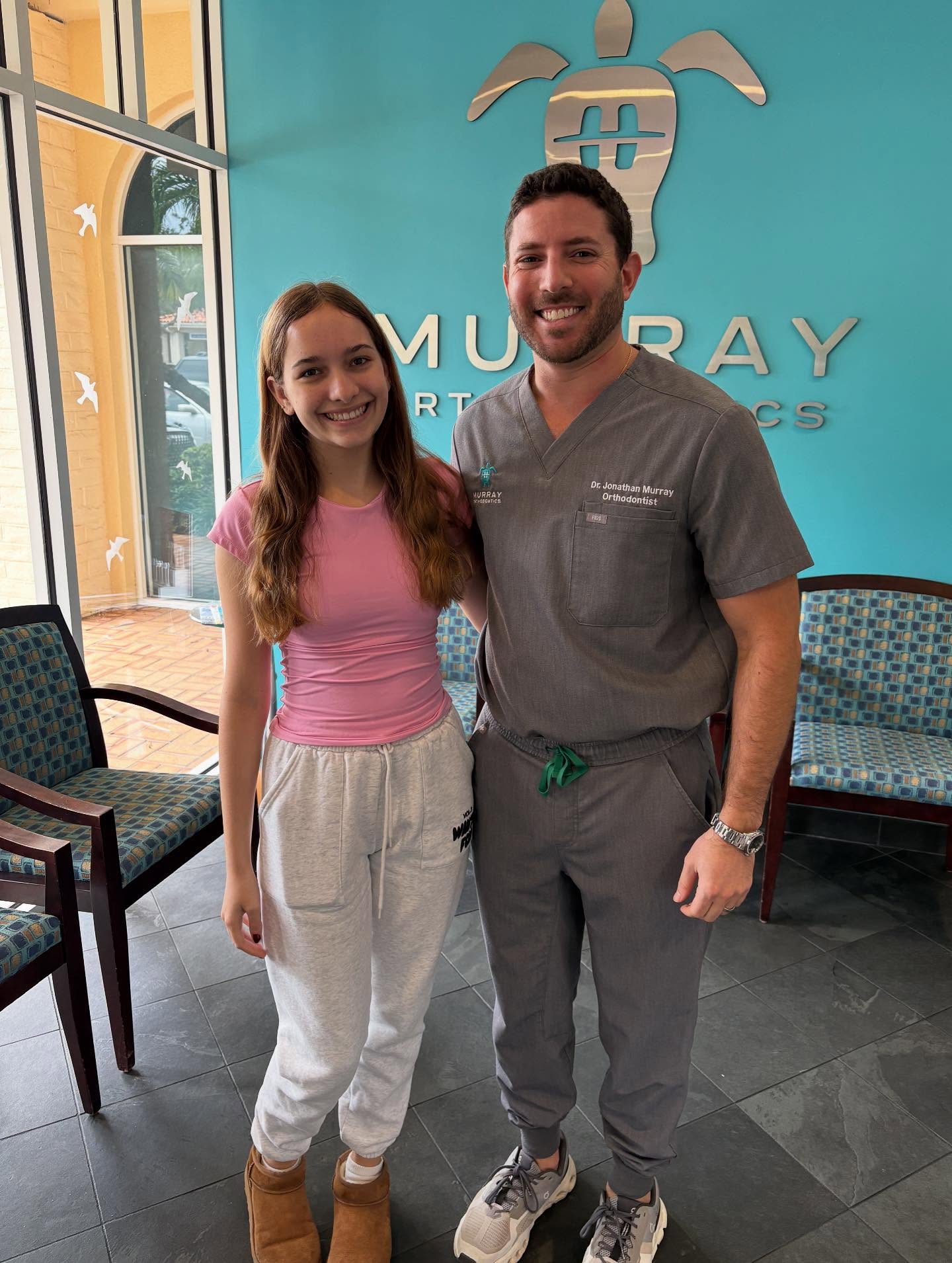 Teen patient Mia with Dr. Jonathan Murray at Murray Orthodontics Palm Beach Gardens office after completing clear aligner treatment