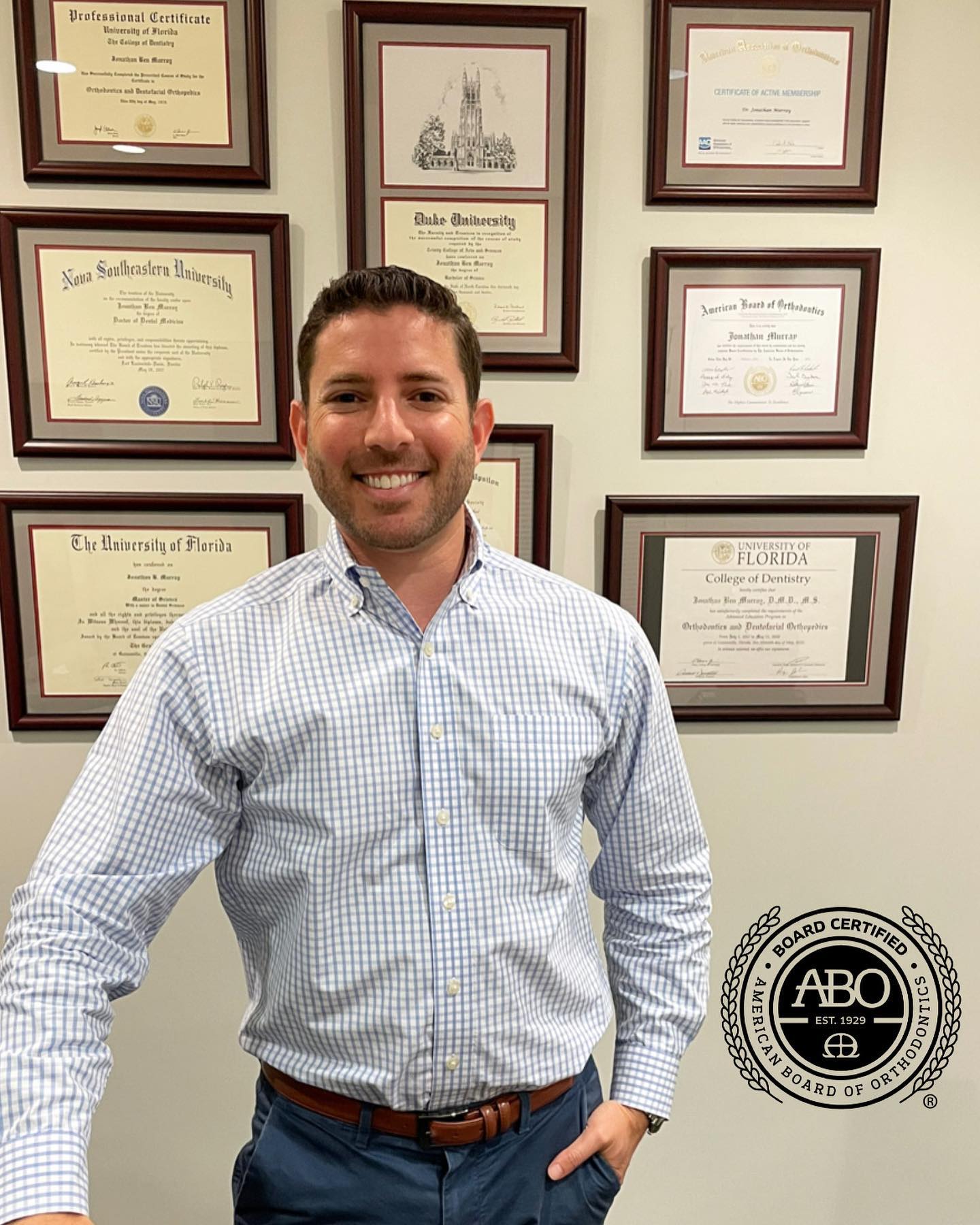 Dr. Jonathan Murray, ABO Board-Certified Orthodontist at Murray Orthodontics in Palm Beach Gardens, standing in front of his University of Florida, Nova Southeastern, and Duke University credentials.