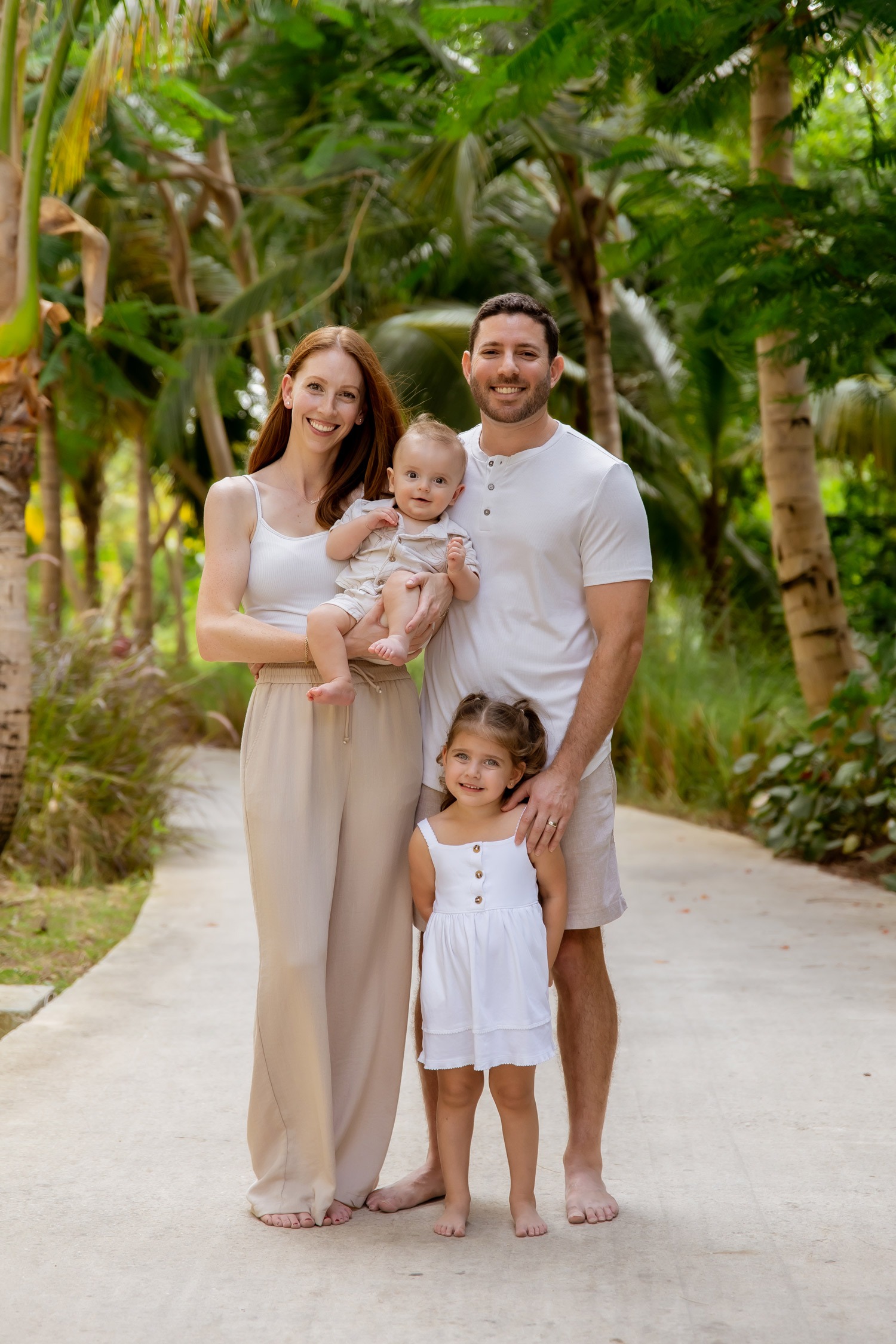 Dr. Jonathan Murray of Murray Orthodontics with his wife Allie and their two children on a palm-lined path in South Florida
