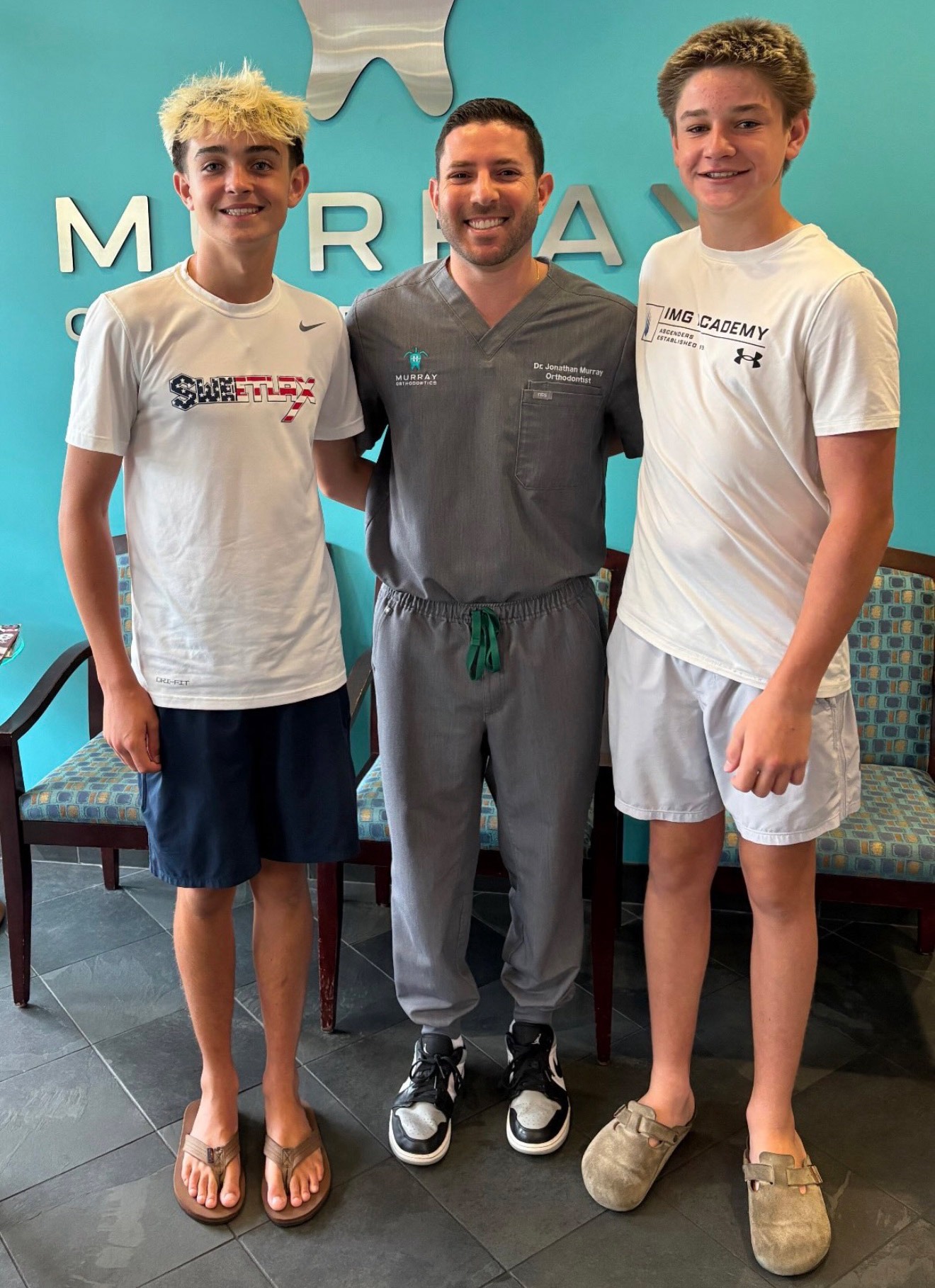 Two teen patients with Dr. Jonathan Murray on braces-off day at Murray Orthodontics in Royal Palm Beach, Florida